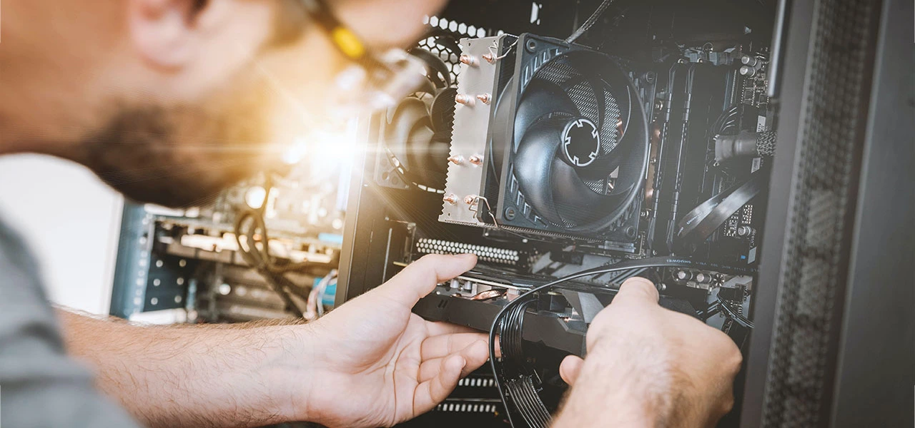 Computer technician inspecting inside an open computer tower.