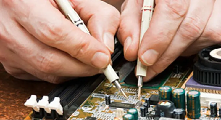 Sarasota Computer Repair technician hands repairing motherboard.
